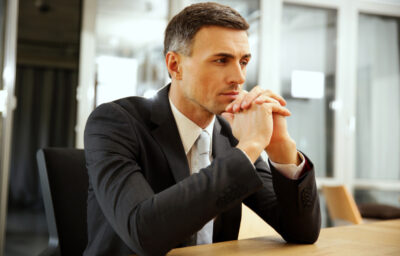 Business man sitting pensively with hands on chin